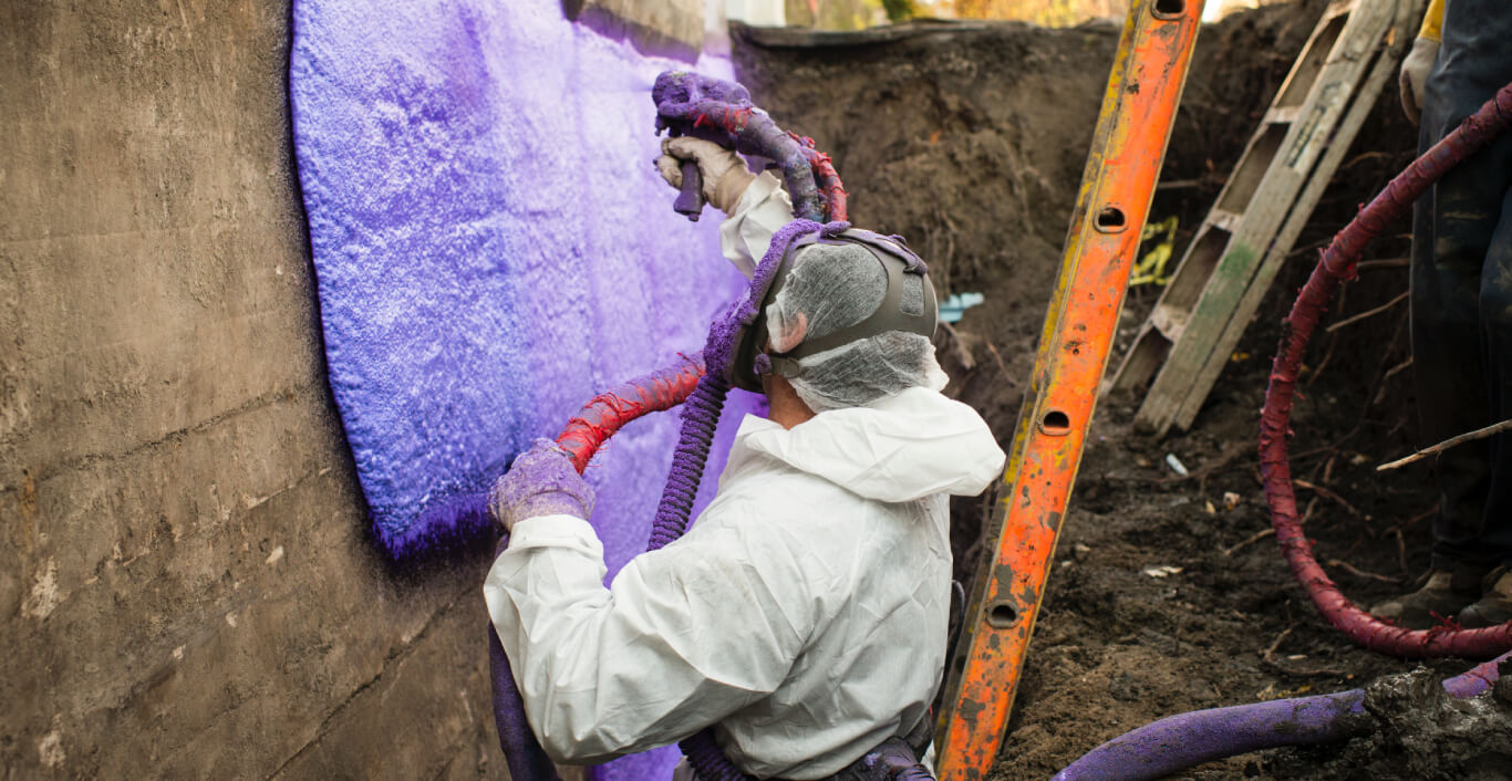 A worker applying waterproofing membrane